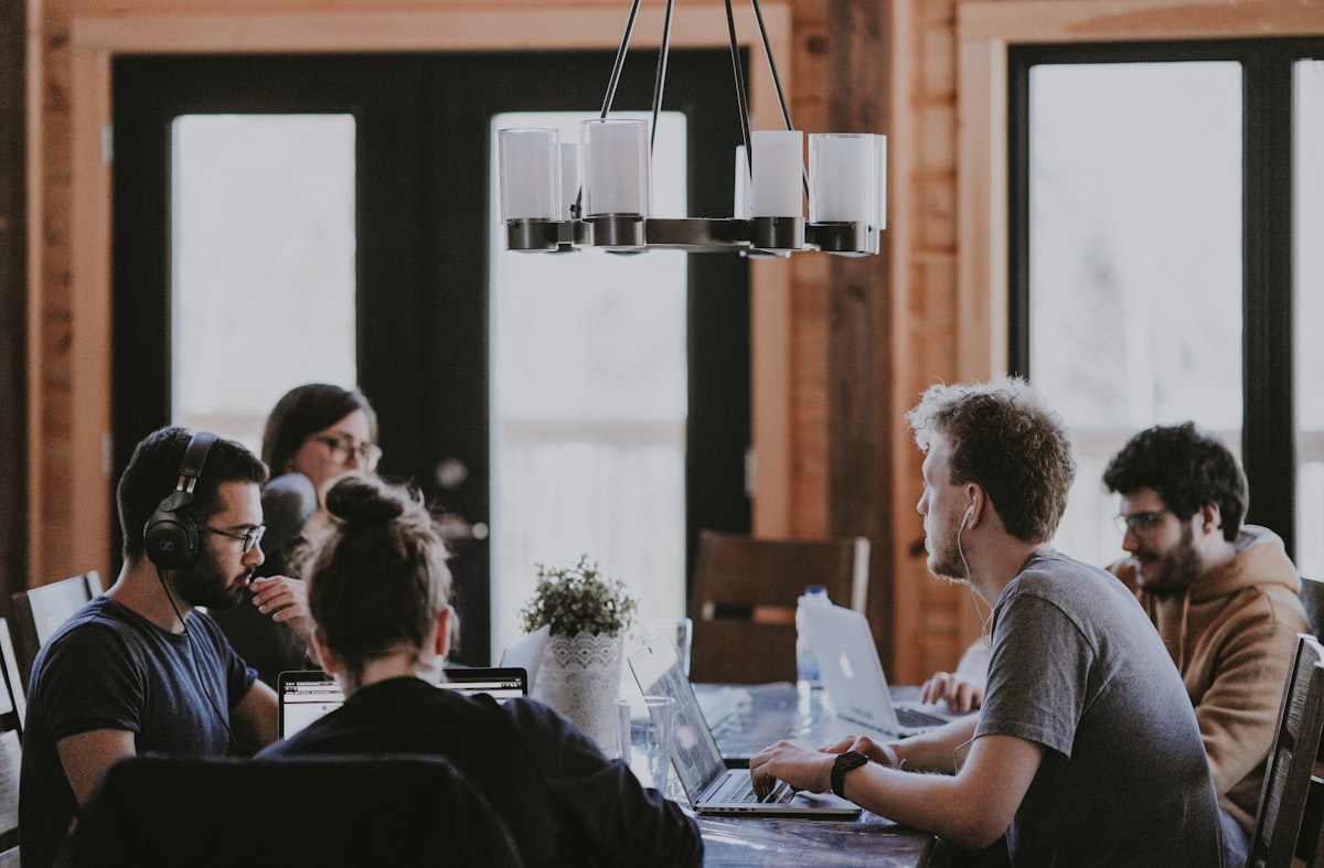 IT operators collaborating around a shared workstation reviewing dashboards and tickets